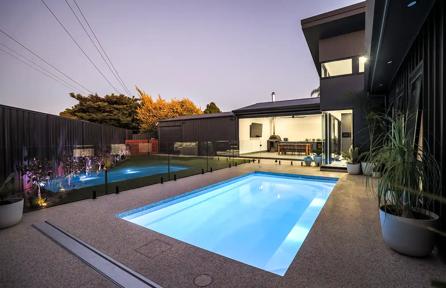 Heron Series Pool at Dusk Heron Series pool illuminated at dusk beside a contemporary outdoor entertaining area