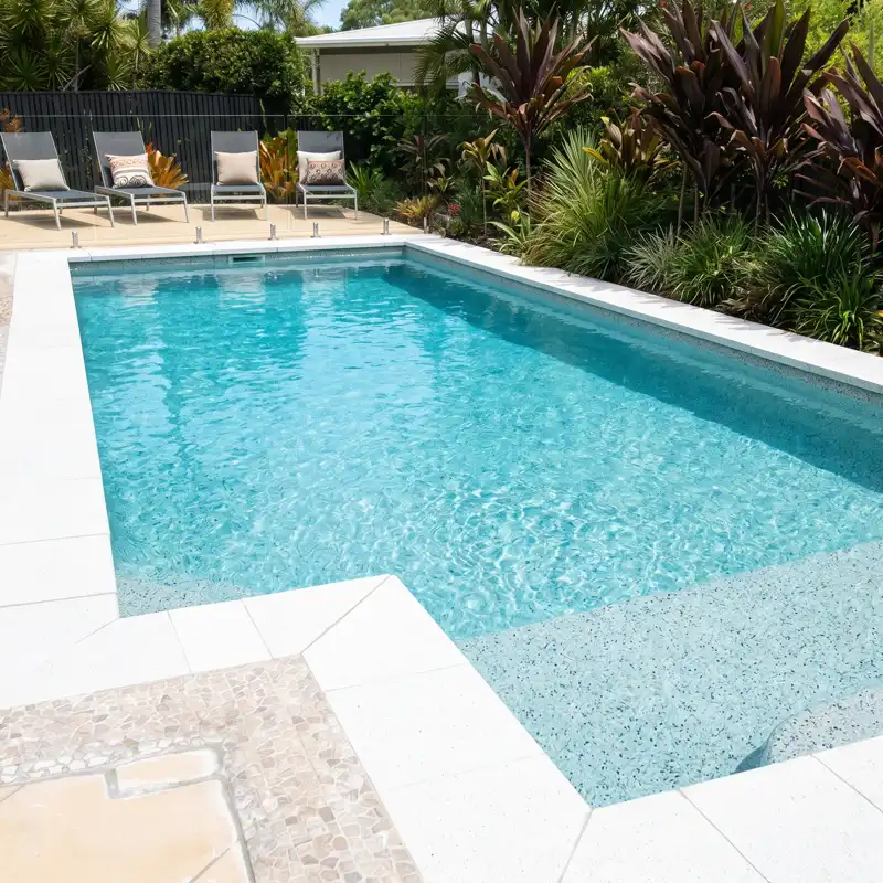 Aggregate concrete pool finish creating vibrant aqua water colour in a custom swimming pool