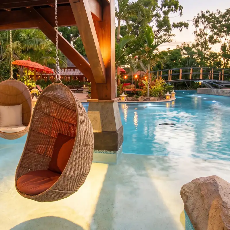 Commercial resort-style concrete pool with tropical landscaping and guest facilities