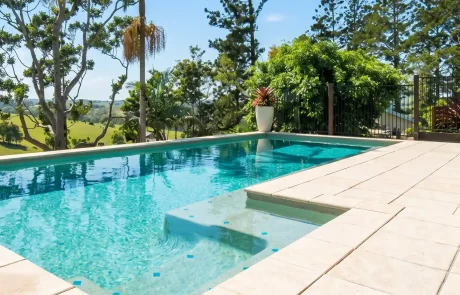 Custom concrete swimming pool on the Sunshine Coast with tiled surrounds and landscaped outdoor living area