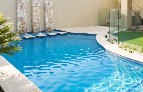 Custom concrete swimming pool with water features, glass fencing and landscaped surrounds on the Sunshine Coast