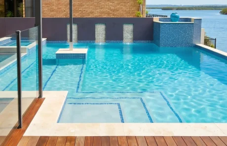 Luxury custom concrete pool with water features overlooking the waterfront