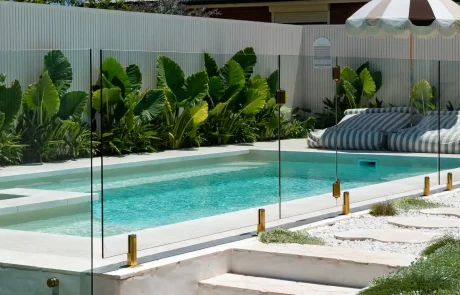 Luxury fibreglass pool with spa area, glass pool fencing and tropical landscaping in a Sunshine Coast backyard.