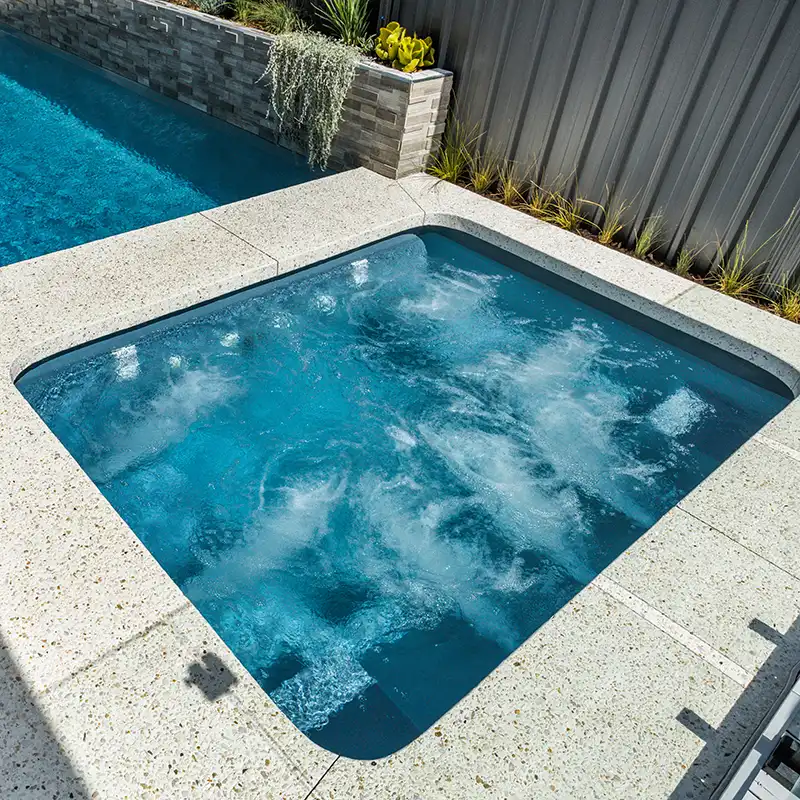 Spa pool with massage jets beside a fibreglass swimming pool
