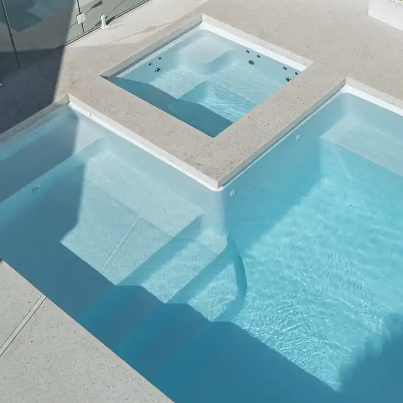 Whitehaven Series fibreglass pool with integrated spa, entry steps and contemporary outdoor design.